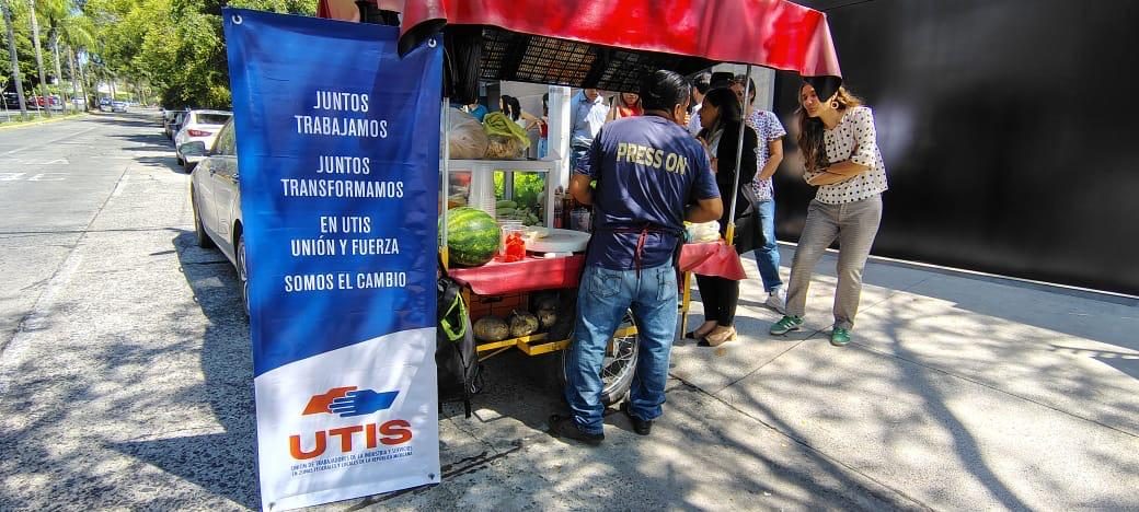 Puesto de fruta junto al estandarte de UTIS